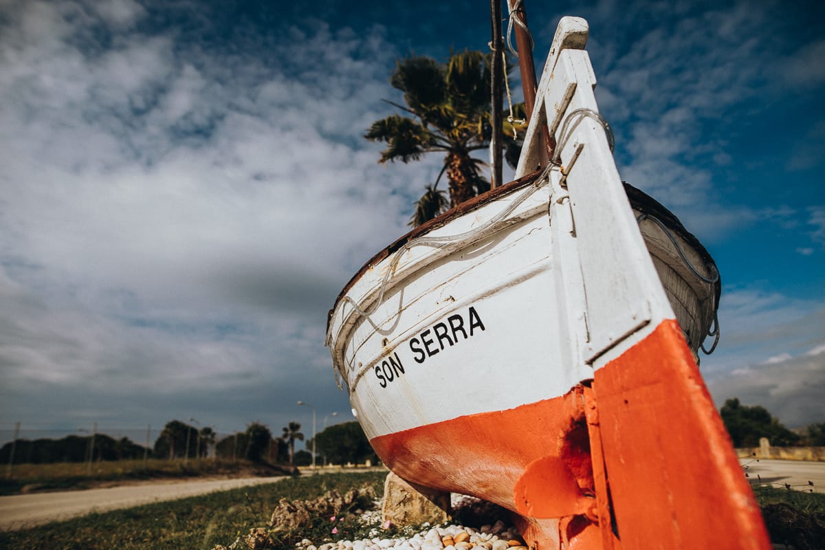 Old boat with the inscription Son Serra as entrance sign of the Mallorcan fishing village.