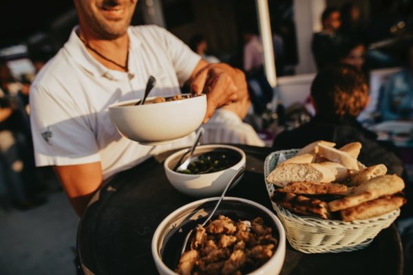 The waiter serves the lifestyle dinner on the terrace of the Bar Sol.