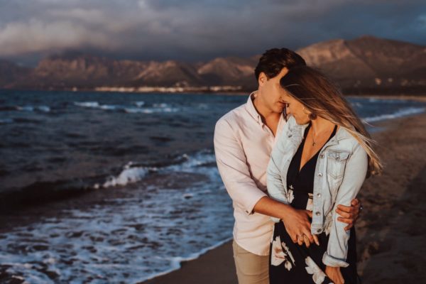 The newlyweds pause to enjoy the sea air and to exchange caresses.