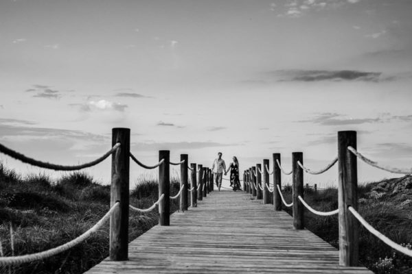 Black and white picture of the newlyweds on the wooden walkway.