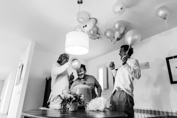 The mens of the family blow up the balloons in the salon.