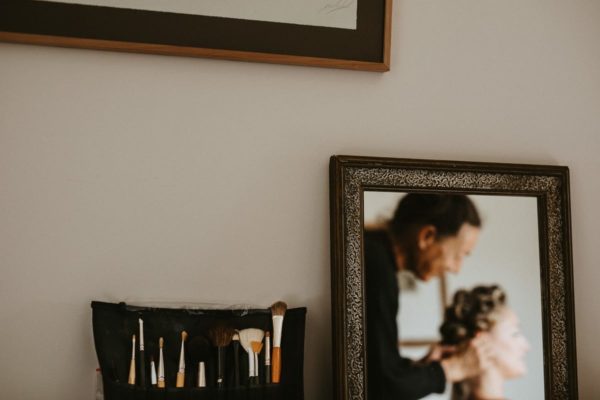 Detail of the make-up brush and reflection of the bride out of focus.
