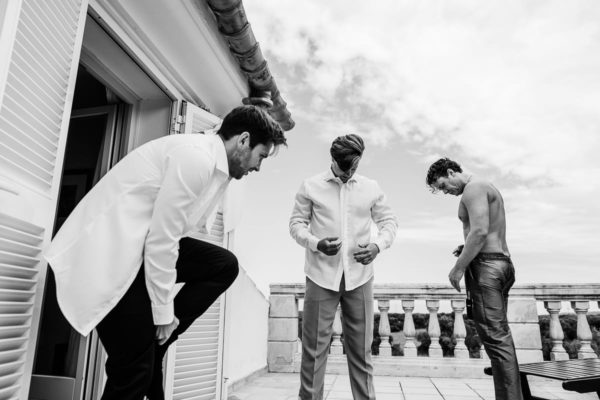 The mens put on their suits on the terrace of the wedding finca being at the fresh air.