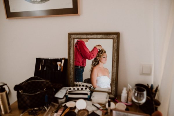 The bride with opened curly hair in the mirror.
