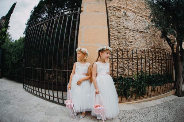 The little bridesmaids stand at the entrance of the church and wait for the bride to come.