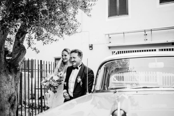 The father and his daughter got out of the vintage wedding car.