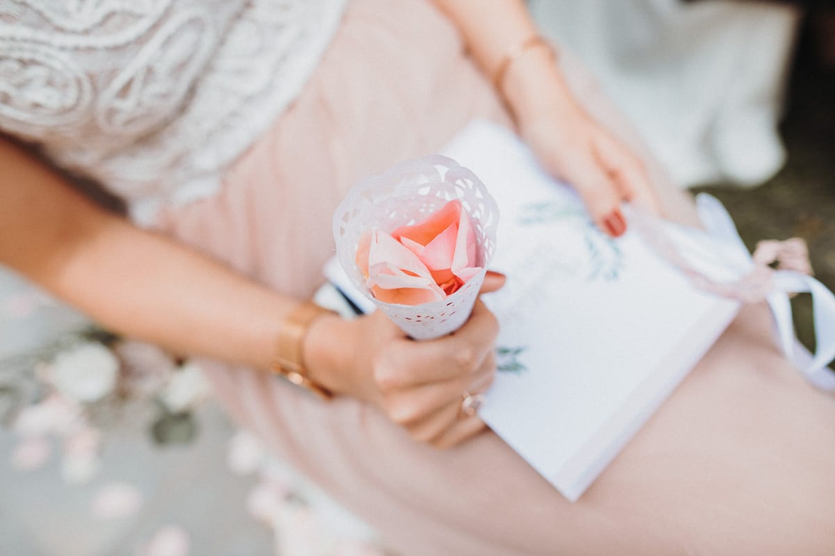 Close-up of a sitting guest holding the rose petals.