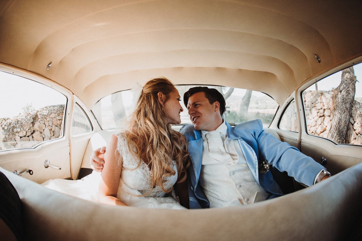 The engaged bride and groom while driving in their wedding car.
