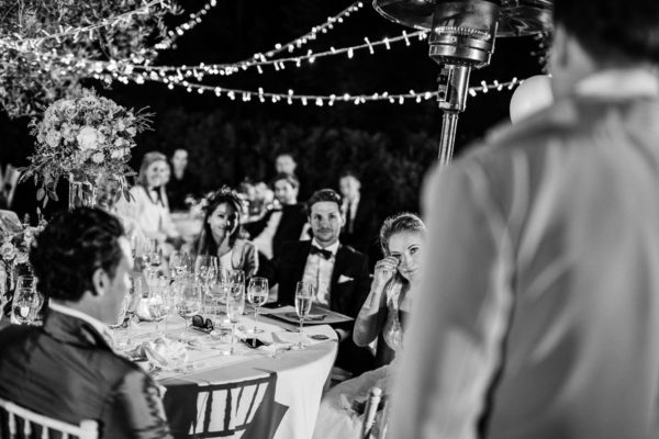 The happy crying bride while she is listening the speech of her husband.