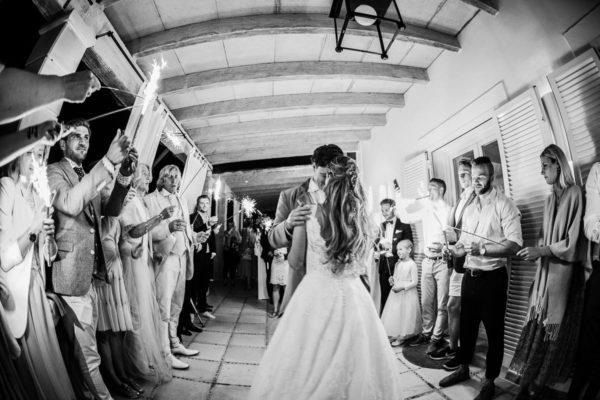 The first dance of the bridal couple in the evening surrounded by their guests with sparklers in their hands.