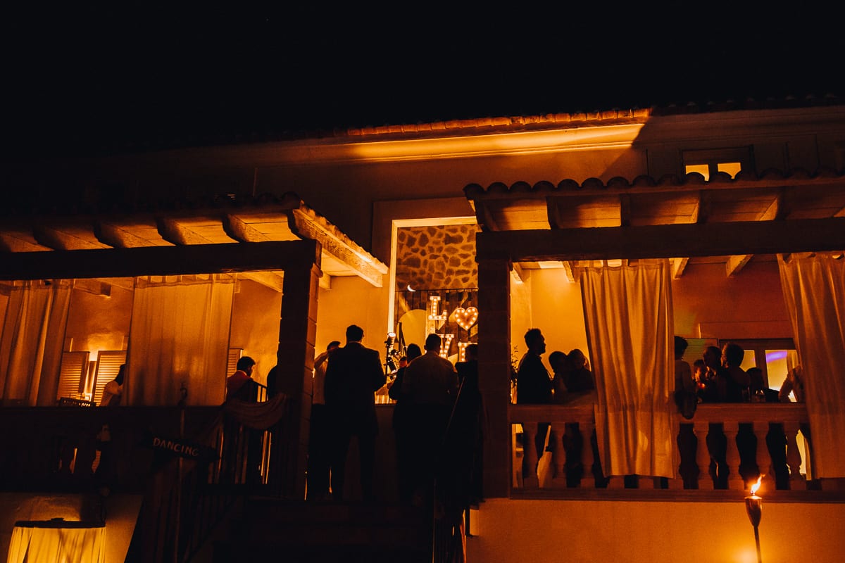 The wedding party terrace by night with the silhouettes of the guests.