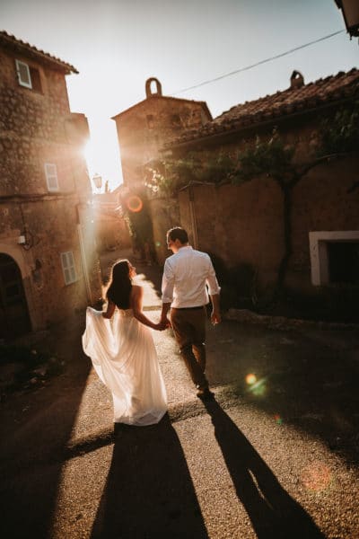 The bridal couple is walking in the small streets of a beautiful village in Majorca.