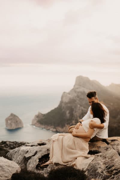 Pregnant couple in front of the seaside of Cap Formentor.