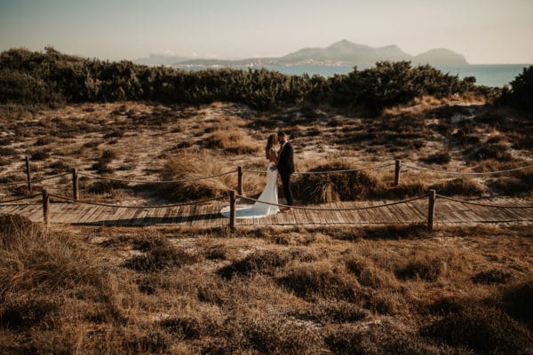Bridal couple in the middle of the dunes closed to the beach in Alcudia