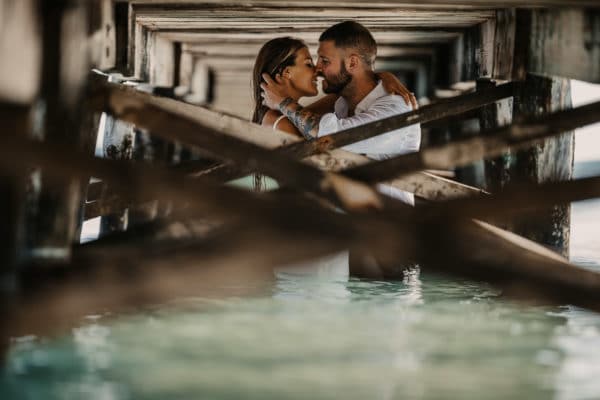 Kissing bridal couple in te water on the beach